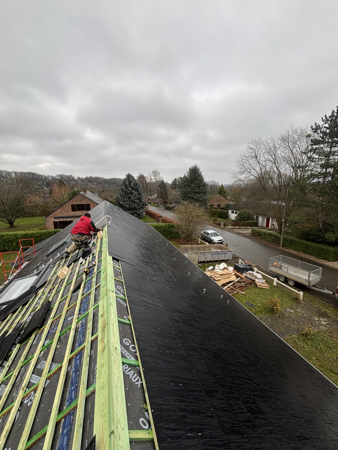Couvreur au travail : lattage et couverture en cours de pose